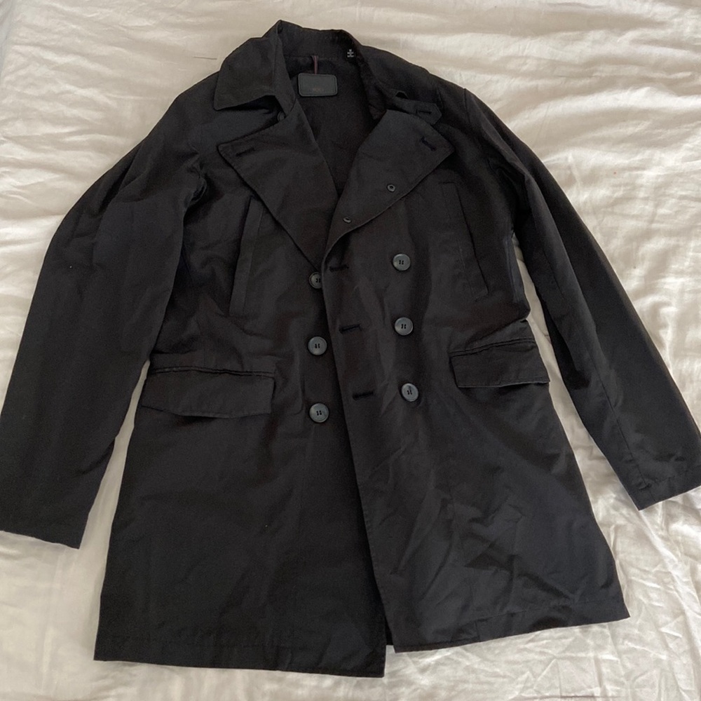 Black Tumi short trench coat.